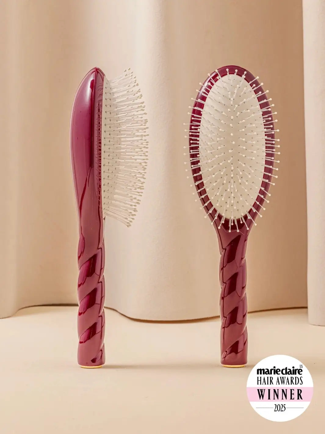 Front and side view of La Bonne Brosse N.04 Large The Detangling & Massaging Miracle Brush in Cherry Red featuring a twisted ergonomic handle and nylon bristles | Twentyseven Toronto