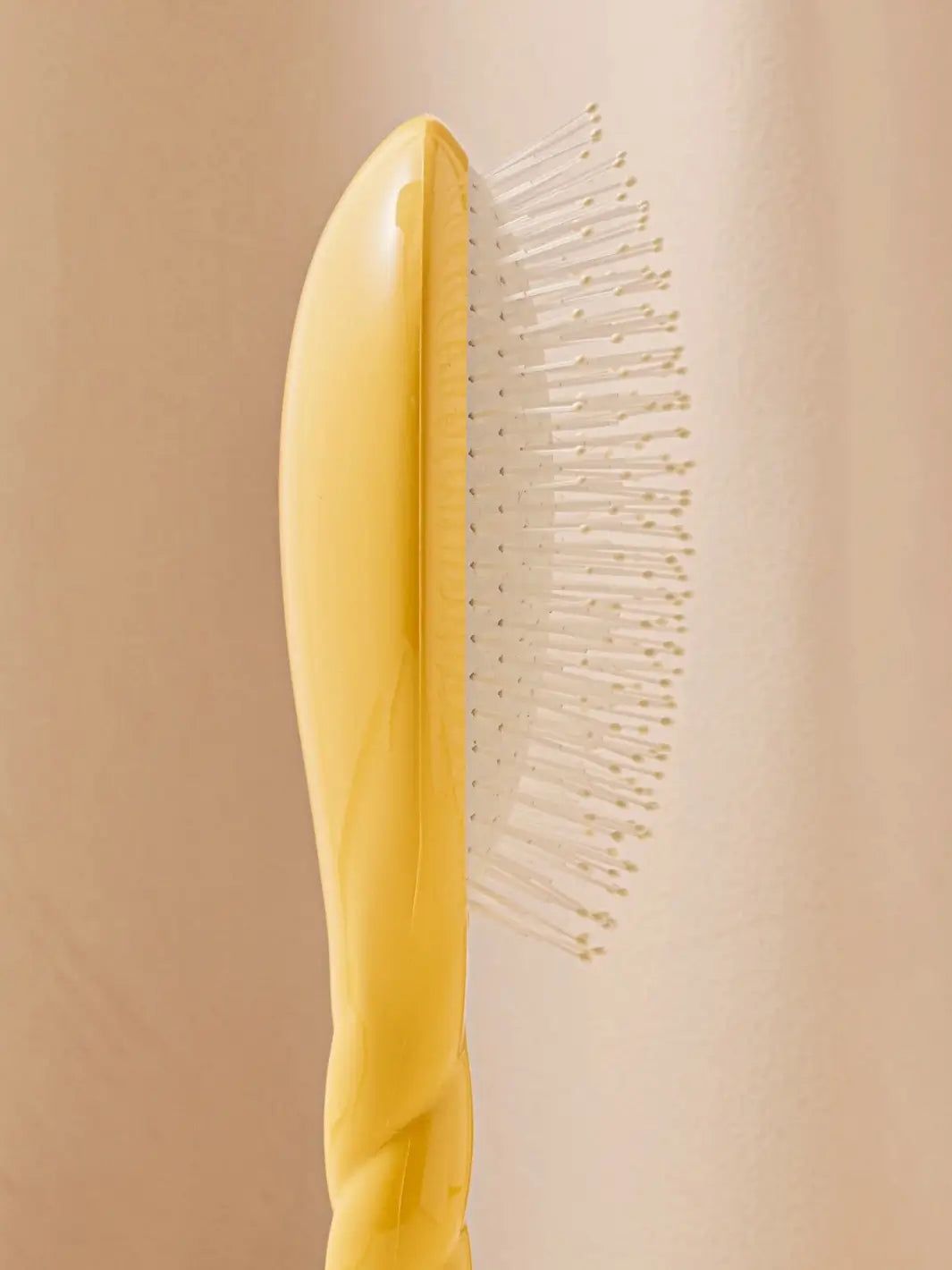 Close-up side view image highlights the nylon bristles of La Bonne Brosse N.04 Large The Detangling & Massaging Miracle Brush in Saffron Yellow  | Twentyseven Toronto