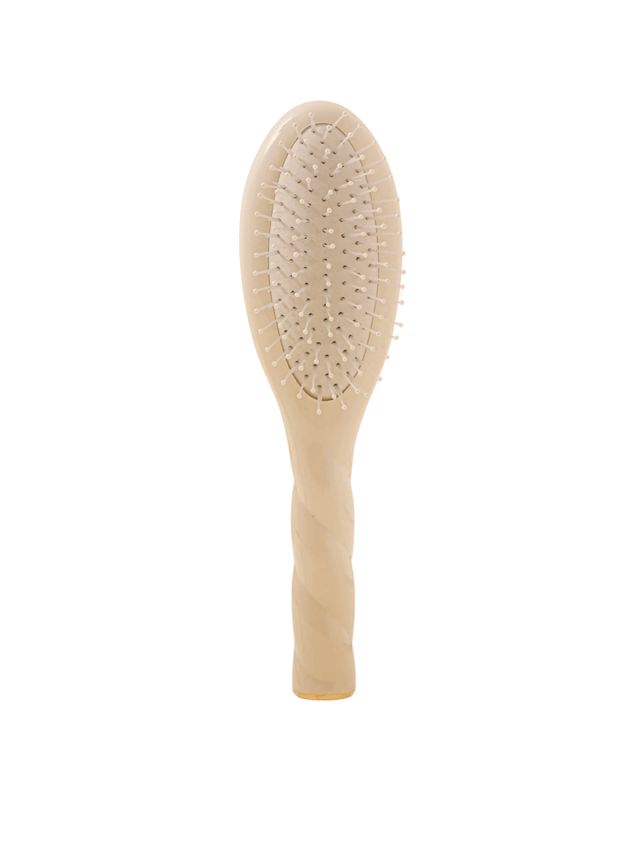 Front view of La Bonne Brosse N.04 Small The Detangling & Massaging Miracle Brush in Creamy White featuring a twisted ergonomic handle and nylon bristles | Twentyseven Toronto