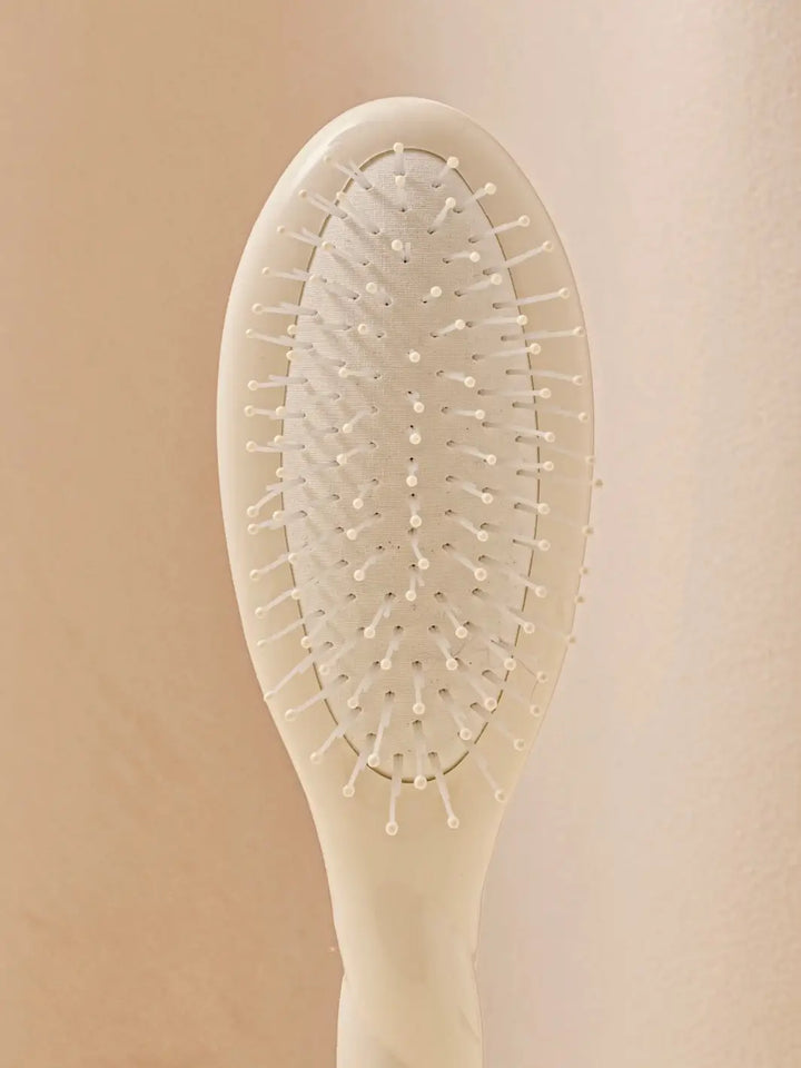 Close up front shot of La Bonne Brosse N.04 Small The Detangling & Massaging Miracle Brush in Creamy White featuring nylon bristles | Twentyseven Toronto