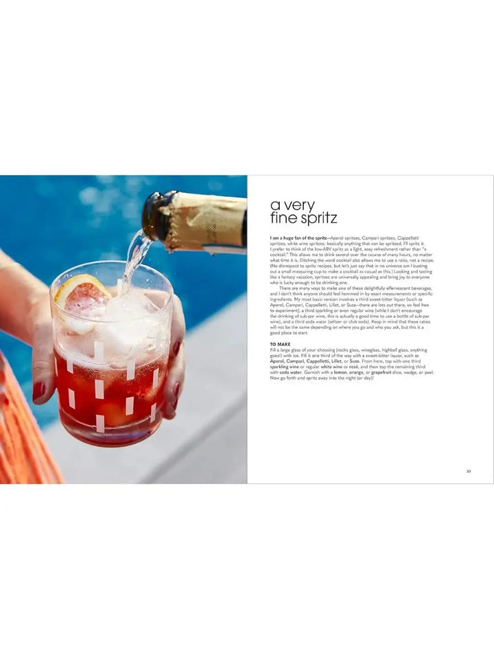 An open cookbook layout shows a recipe titled "a very fine spritz" next to a hand holding a bubbly cocktail garnished with a citrus slice, from Nothing Fancy: Unfussy Food for Having People Over by Alison Roman | Twentyseven Toronto