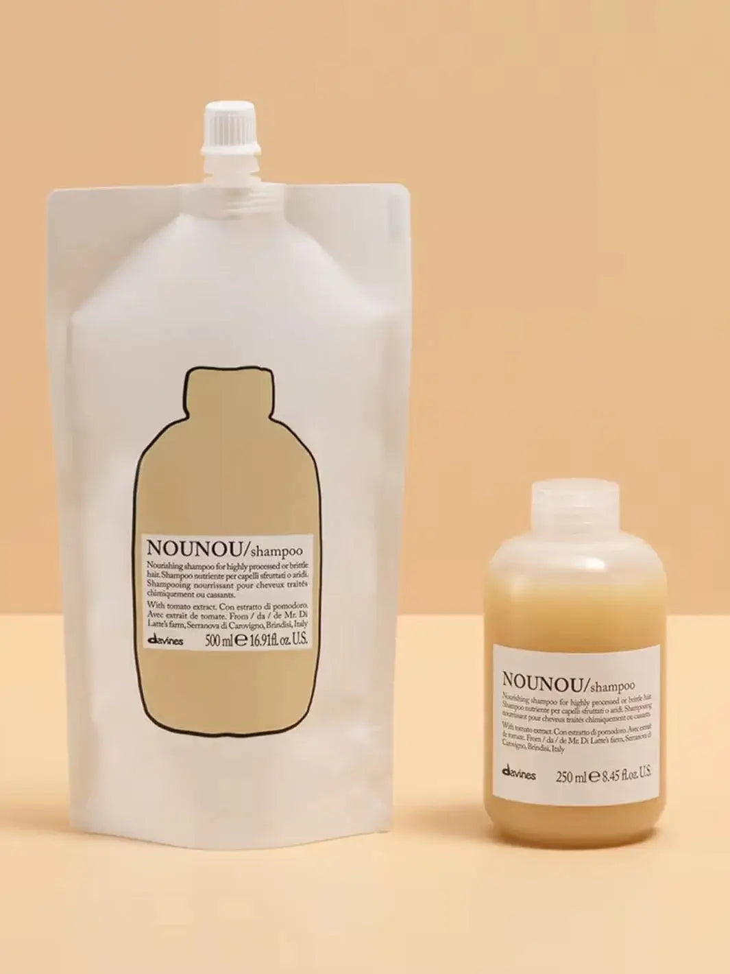 A white pouch of Davines NOUNOU Shampoo Refill stands next to a smaller bottle filled with yellow shampoo against a yellow background | Twentyseven Toronto