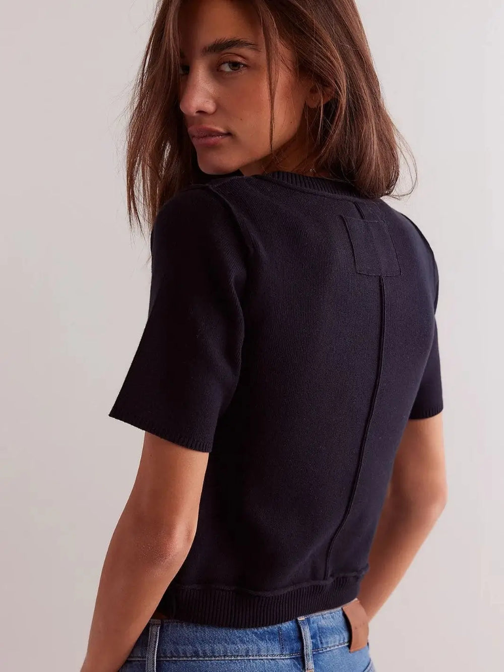 A view from behind highlights the clean crew neckline, fine knit texture, and vertical back seam detail of the Free People We The Free NY Twosie - Black | Twentyseven Toronto
