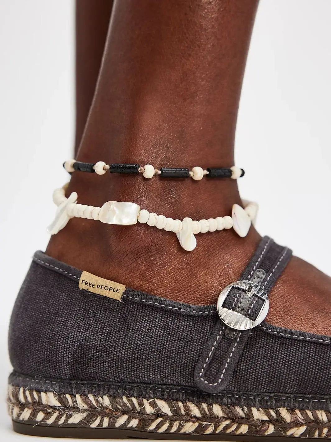 A close-up side angle focuses on the buckle strap detail and textured woven sole of the Free People Oasis Mary Jane Espadrilles - Washed Black | Twentyseven Toronto