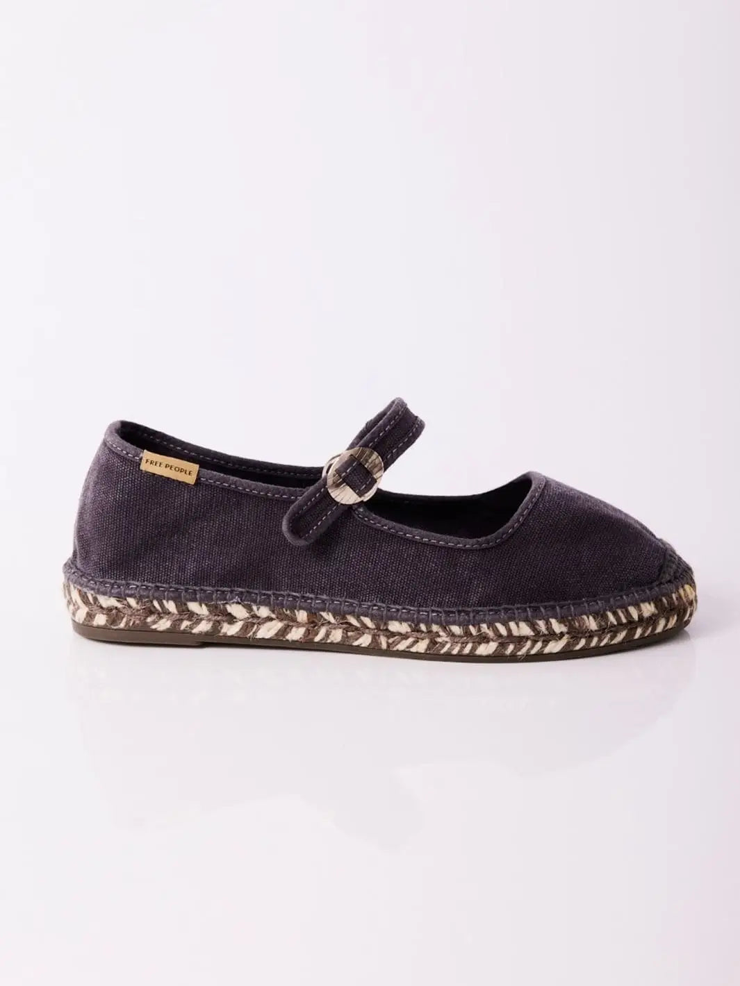 A side profile product shot displays the flat silhouette, adjustable instep strap, and signature logo tag of the Free People Oasis Mary Jane Espadrilles - Washed Black | Twentyseven Toronto