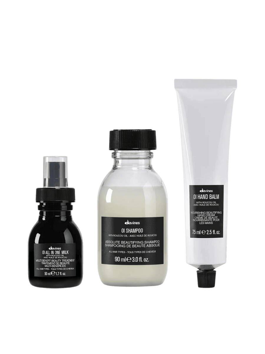Three Davines products on a transparent background, featuring the OI All in One Milk (50ml), OI Shampoo (50ml, and OI Hand Balm (75ml) | Twentyseven Toronto