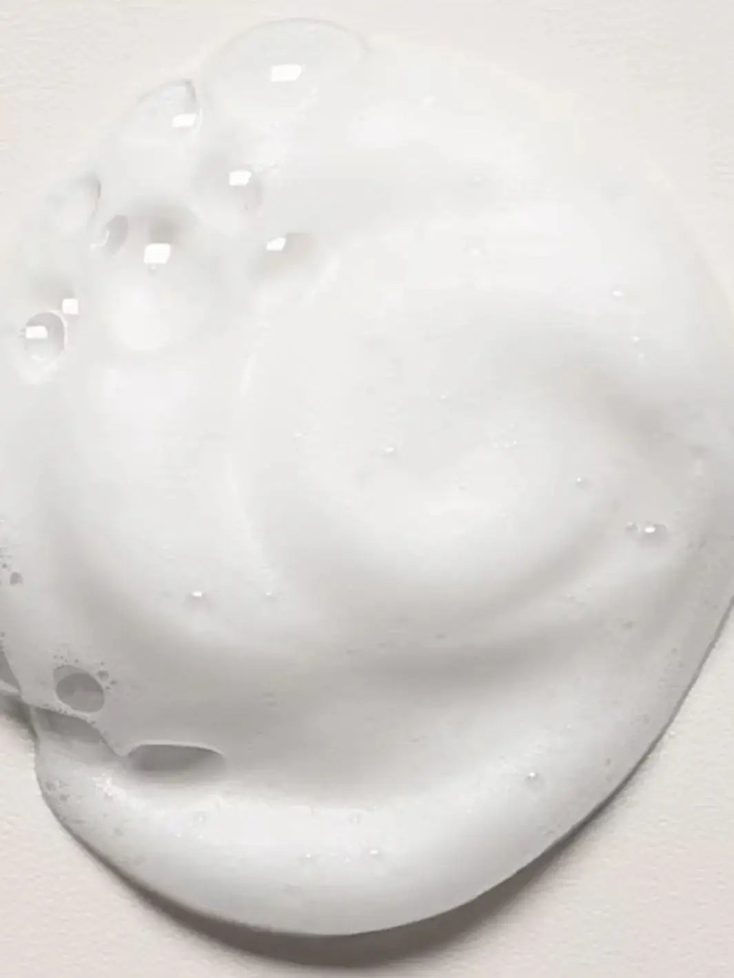 A close-up shot displays a dollop of airy white foam from Davines OI Soufflé | Twentyseven Toronto