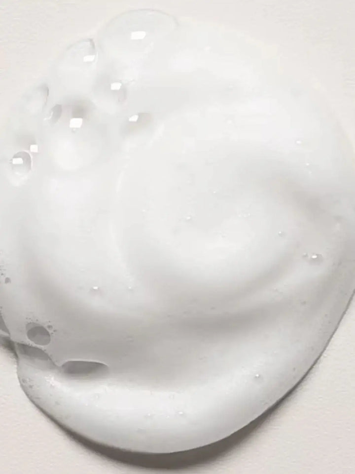 A close-up shot displays a dollop of airy white foam from Davines OI Soufflé | Twentyseven Toronto