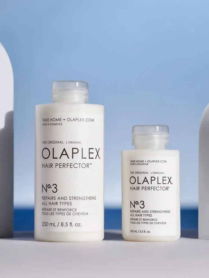 Two bottles of Olaplex Hair Perfector No. 3, one 100ml and one 250ml on a light blue background | Twentyseven Toronto