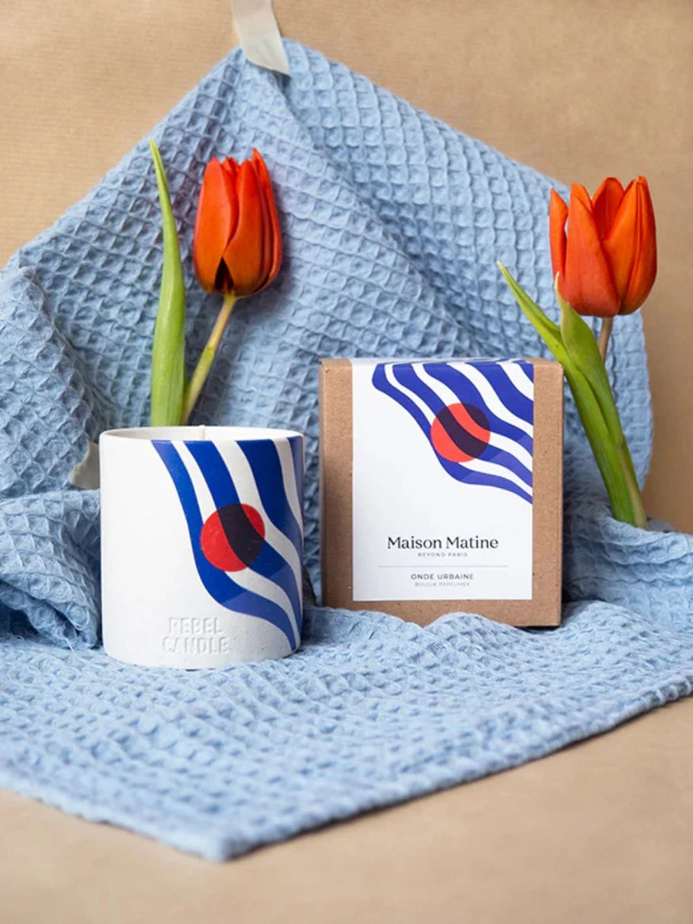 Maison Matine Onde Urbaine Scented Candle with packaging, and tulips on a textured blue cloth with a beige background 160g | Twentyseven Toronto