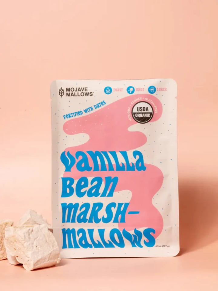 A white bag of Mojave Mallows Organic Vanilla Bean Marshmallows with bold blue and pink typography against a soft pink background | Twentyseven Toronto