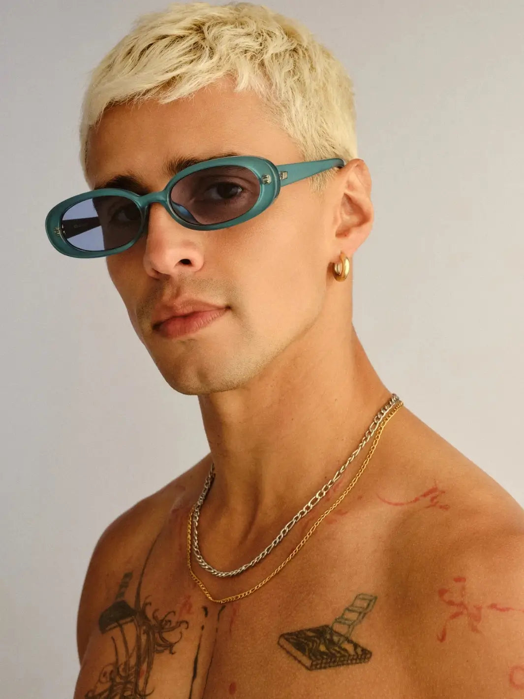 A portrait of a man with blonde hair looking forward while wearing the slim Le Specs Sunglasses Outta Love + in Blue Pearl | Twentyseven Toronto
