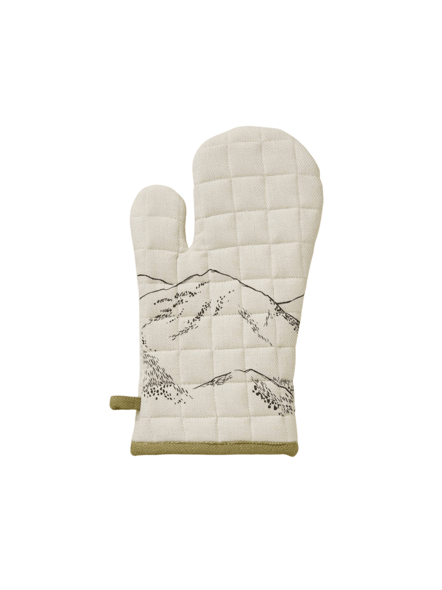 White quilted oven mitt with mountain design and olive green borders from Sylvie Thiriez on a transparent background | Twentyseven Toronto