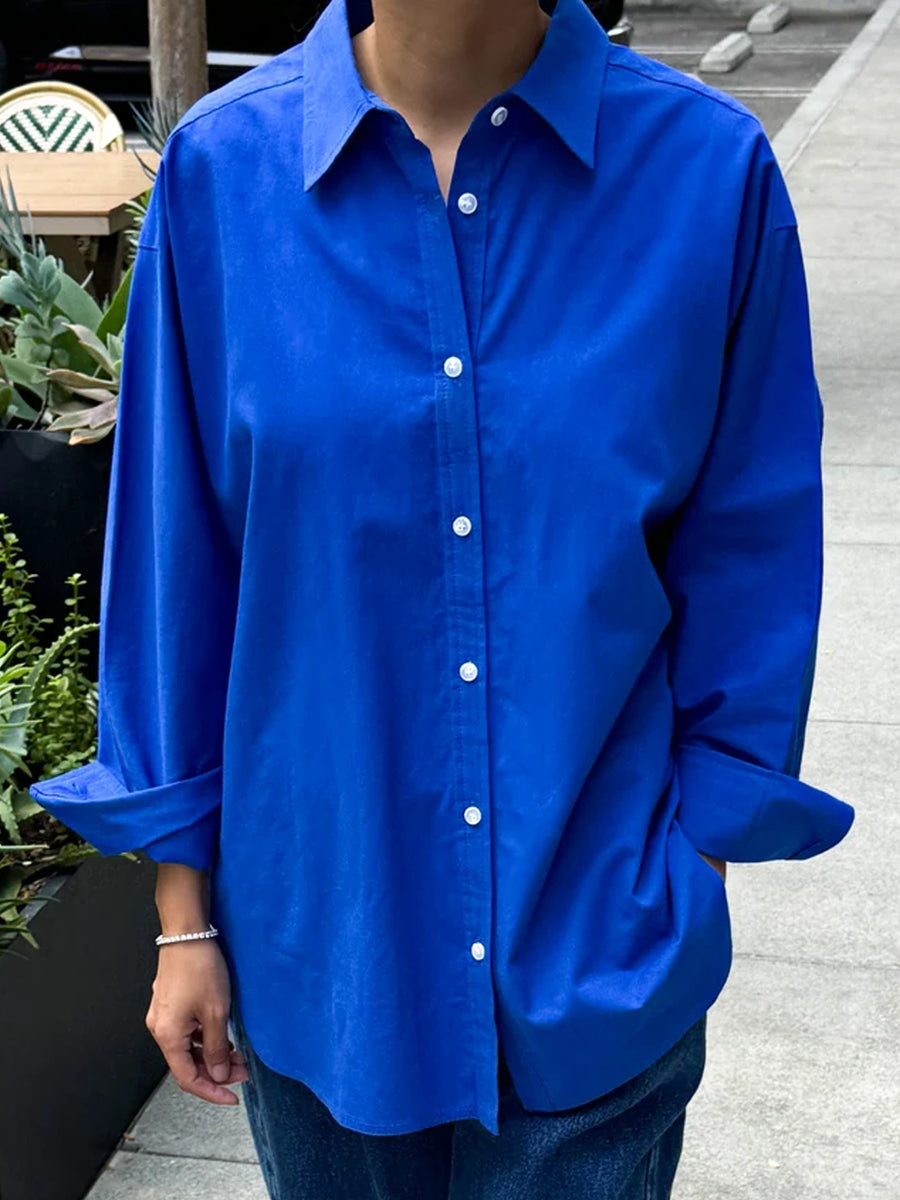 Model wearing the Le Bon Shoppe Owen Shirt in Cobalt, an oversized blue button-down shirt with rolled sleeves, styled with dark denim jeans | Twentyseven Toronto