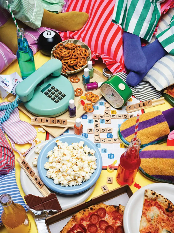 Piecework Puzzles 'Pajama Party' 1000 piece puzzle featuring a colourful table setting with snacks, drinks, and a rotary phone | Twentyseven Toronto