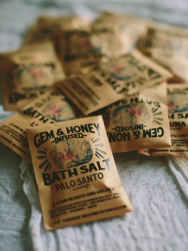 A scattered pile of brown paper packets of the Palo Santo Bath Soak and Body Scrub from Wild Yonder Studio | Twentyseven Toronto