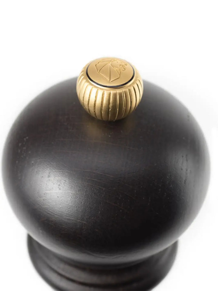 Black 'Paris U'Select Wood' pepper grinder in 'Chocolate Finish' with gold top from Peugeot on a white background | Twentyseven Toronto