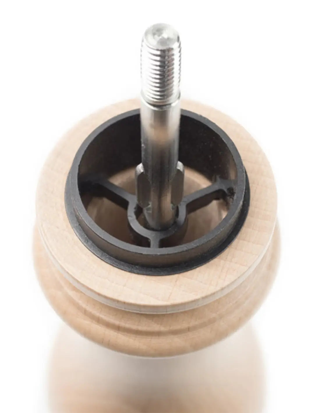 Close-up of a metal wheel from Peugeot 'Paris U'Select Wood Pepper Mill' with a central shaft on a white background | Twentyseven Toronto