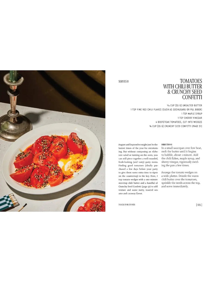 Recipe spread from Party Tricks: Easy, Elegant Recipes for Snacking and Hosting by Anna Hezel titled "Tomatoes with Chili Butter & Crunchy Seed Confetti," showing a white platter of thick tomato wedges drizzled with a bright orange chili oil | Twentyseven Toronto
