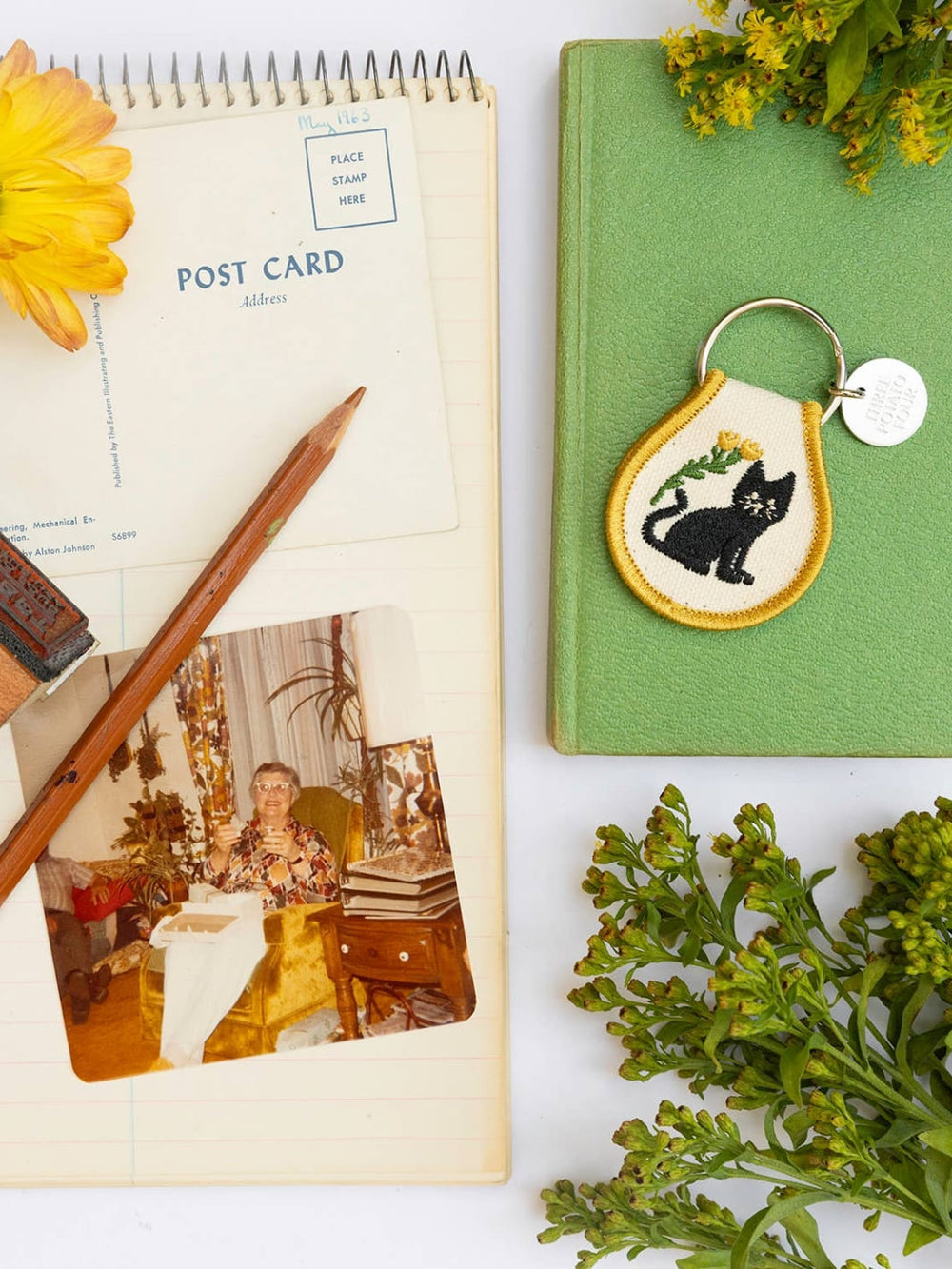 Patch keychain with embroidered black cat and yellow flower design from Three Potato Four with post cards and photo backgrounds | Twentyseven Toronto