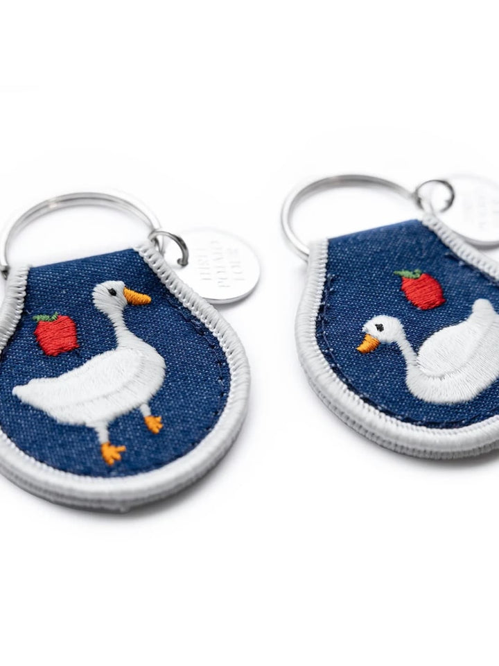Two denim keychains with goose and apple design on a white background, from the brand 'Three Potato Four' | Twentyseven Toronto