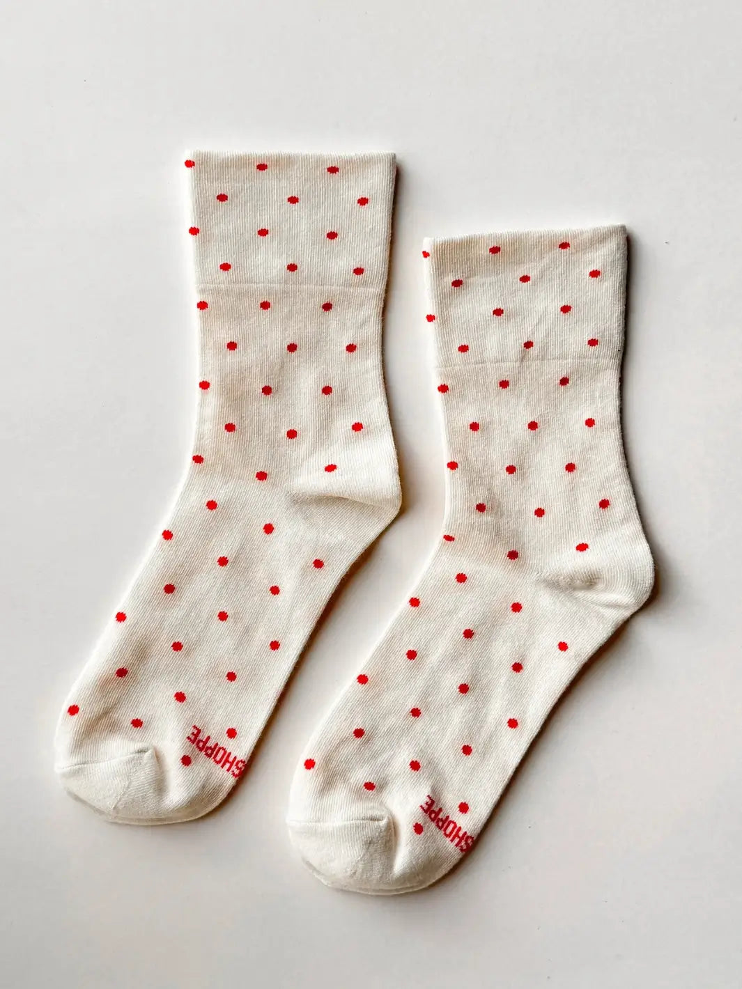 Pair of white socks with red polka dots from Le Bon Shoppe on a light gray background | Twentyseven Toronto