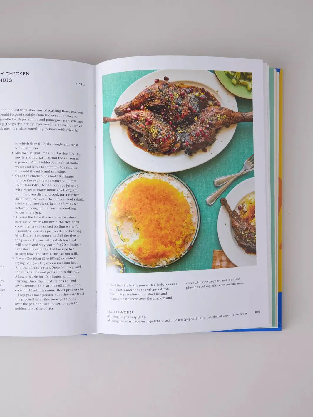 Page from the cookbook Peckish: An Inspirational Collection of Winning Chicken Dinners by Ed Smith displays a recipe for chicken with saffron rice, accompanied by roasted chicken legs garnished with pomegranate seeds and pistachios next to a golden, crispy disc of tahdig rice | Twentyseven Toronto