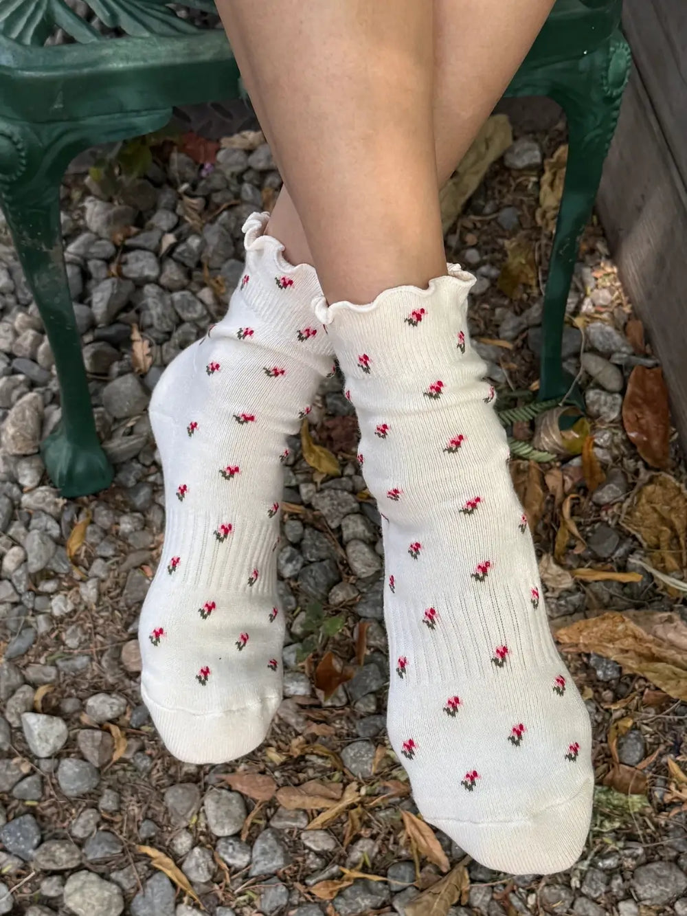 A person sitting on a bench wears the Le Bon Shoppe Petal Ruffled Hugger Crew Socks in Cream Petal featuring ruffled cuffs and a tiny floral print | Twentyseven