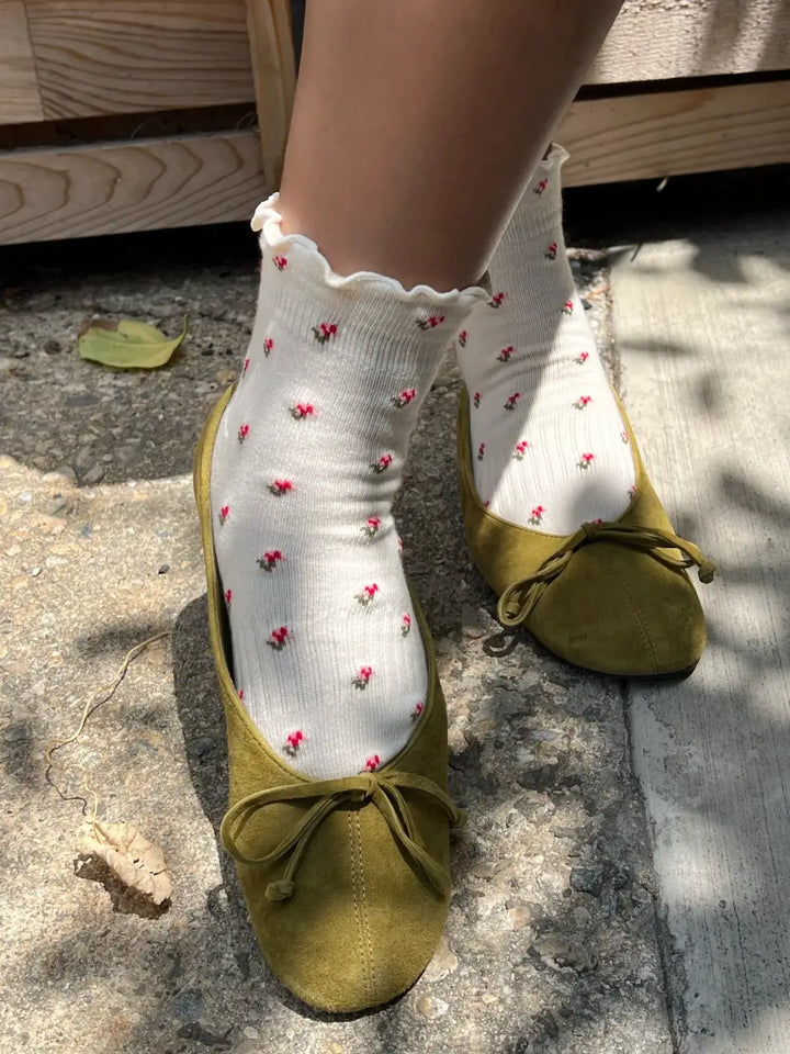 A person wears the Le Bon Shoppe Petal Ruffled Hugger Crew Socks in Cream Petal styled with olive green suede ballet flats | Twentyseven