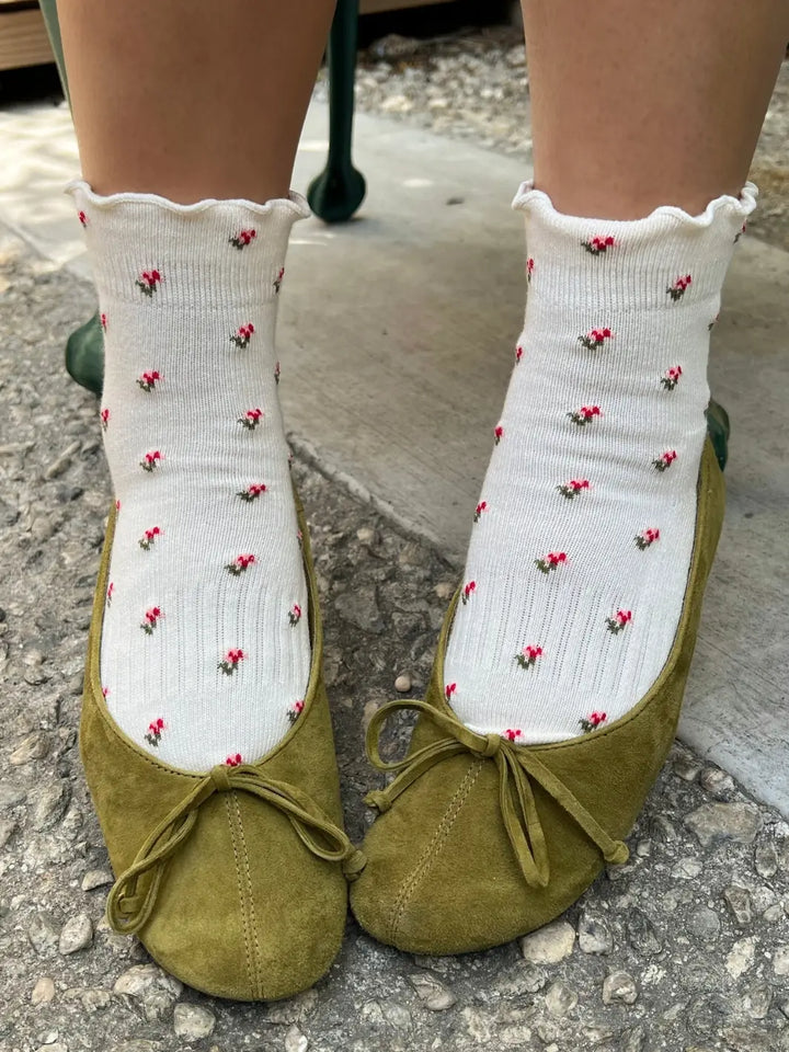A front-facing view shows a person wearing the floral-patterned Le Bon Shoppe Petal Ruffled Hugger Crew Socks in Cream Petal paired with green ballet flats | Twentyseven