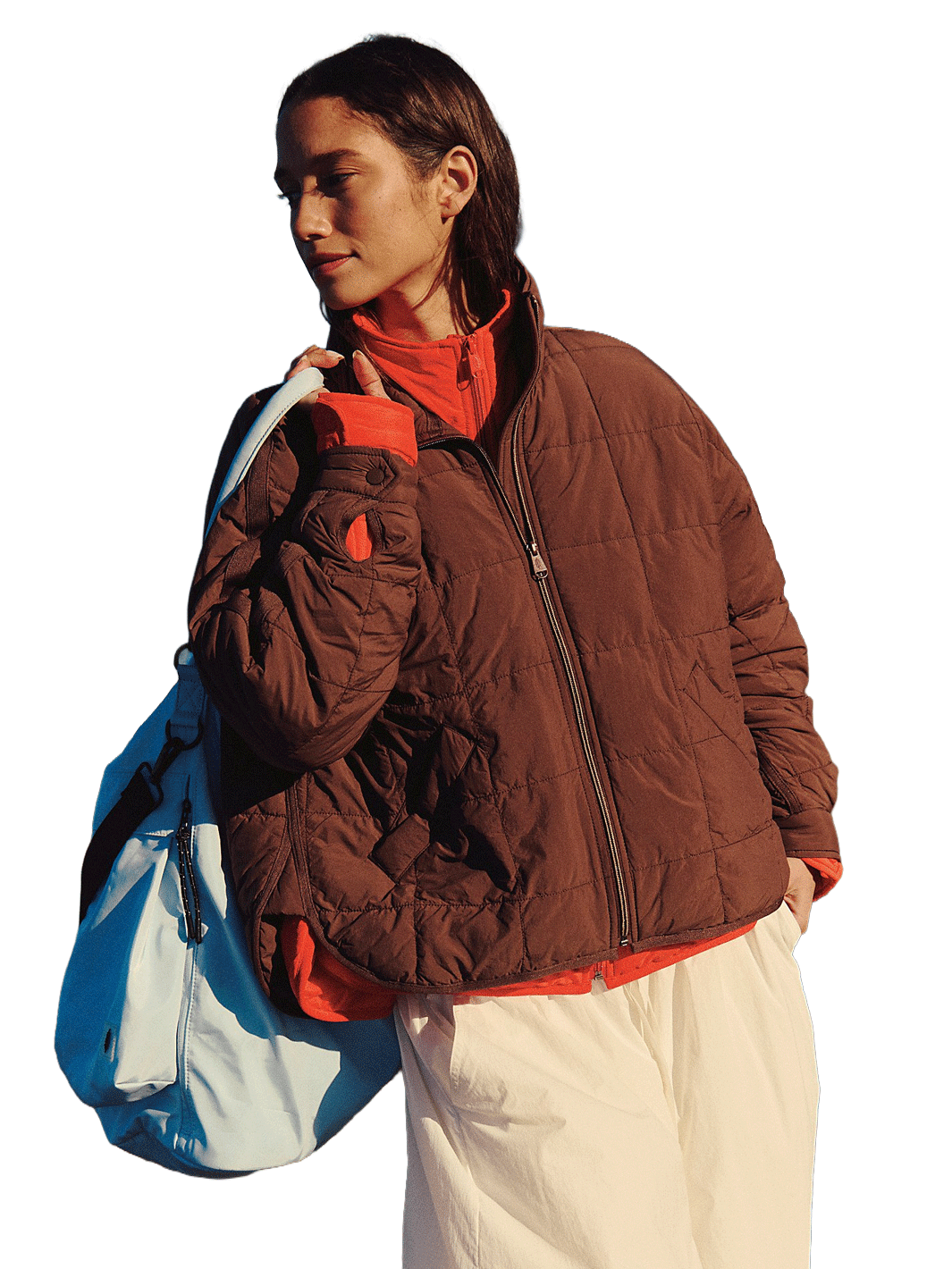 Free People Movement Pippa Packable Puffer in Cocoa styled over a red zip-up with white pants and a blue duffle bag | Twentyseven Toronto