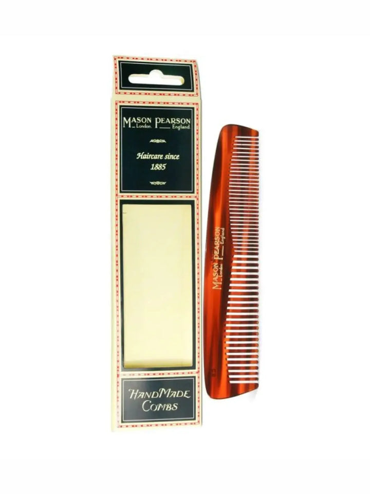 A premium tortoiseshell comb with fine and coarse teeth is displayed next to its traditional cream and navy blue cardboard box to showcase the design of the Mason Pearson Pocket Comb C5 | Twentyseven Toronto