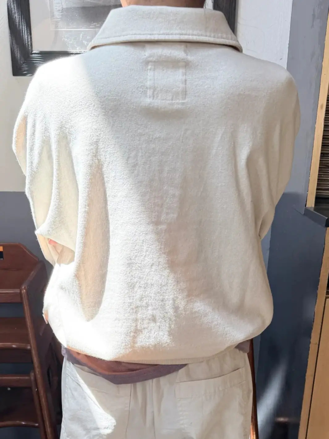 A back view highlights the relaxed fit and classic collar of a cream-colored Le Bon Shoppe Polo Sweatshirt in Naturel worn by a model | Twentyseven Toronto