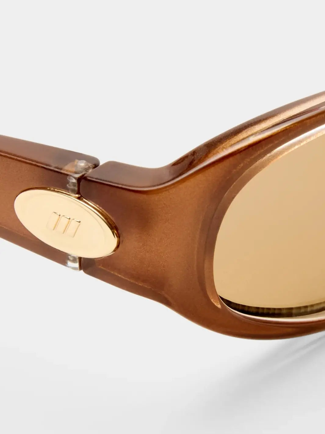A macro close-up highlighting the hinge construction and small gold metal emblem on the side of the Le Specs Popalicious + | Pearl Caramel sunglasses frame | Twentyseven Toronto