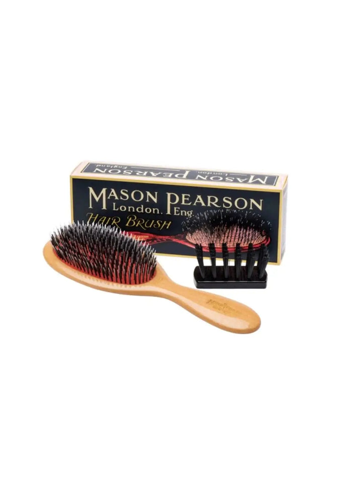 Brown Mason Pearson Popular Lightwood Hairbrush BN1W is displayed on a white surface alongside its official navy blue product packaging and a small black cleaning brush | Twentyseven Toronto