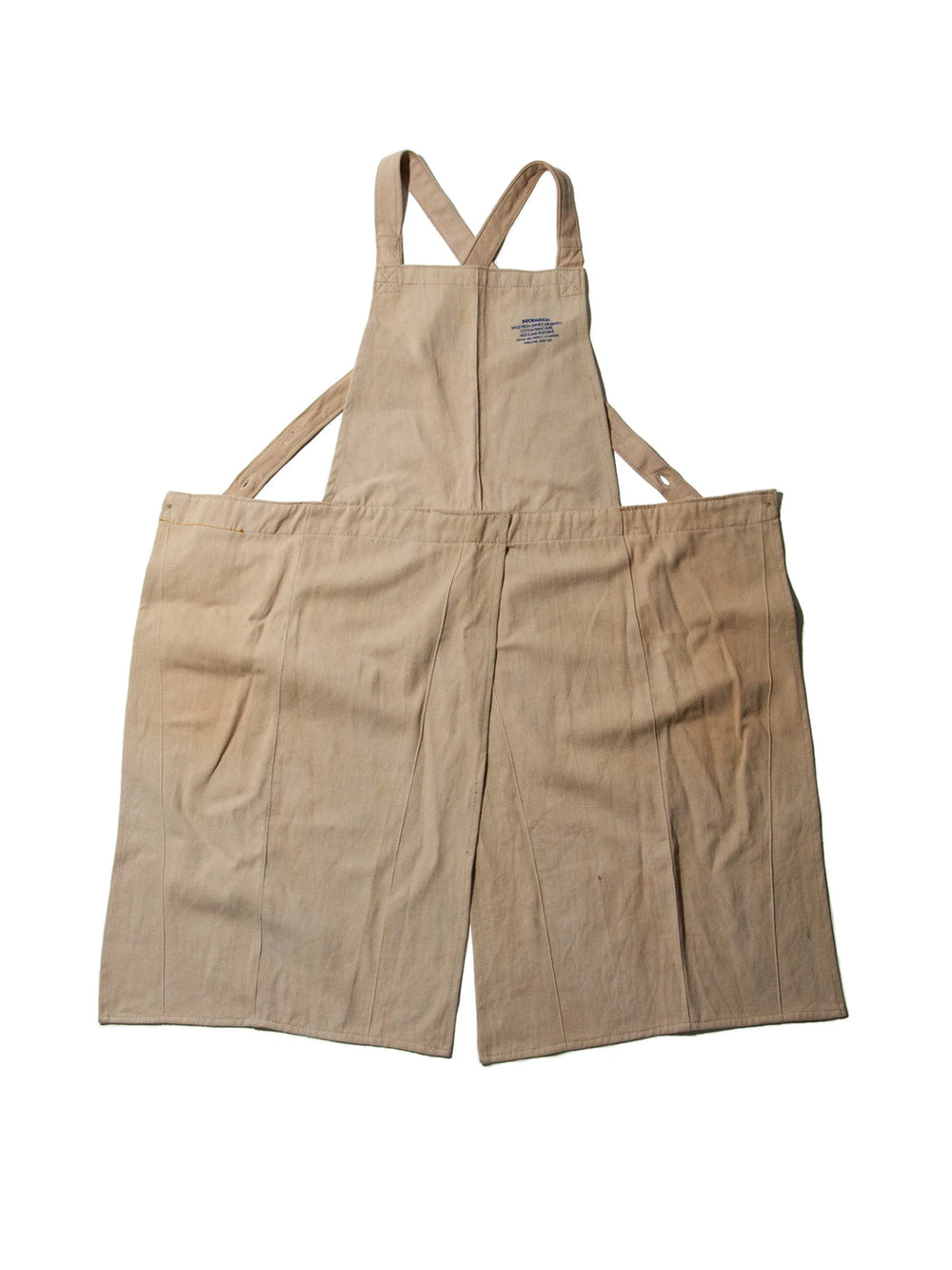 Puebco Potters Apron in beige repurposed cotton fabric, featuring crossed shoulder straps, a split front design and subtle printed detailing | Twentyseven Toronto
