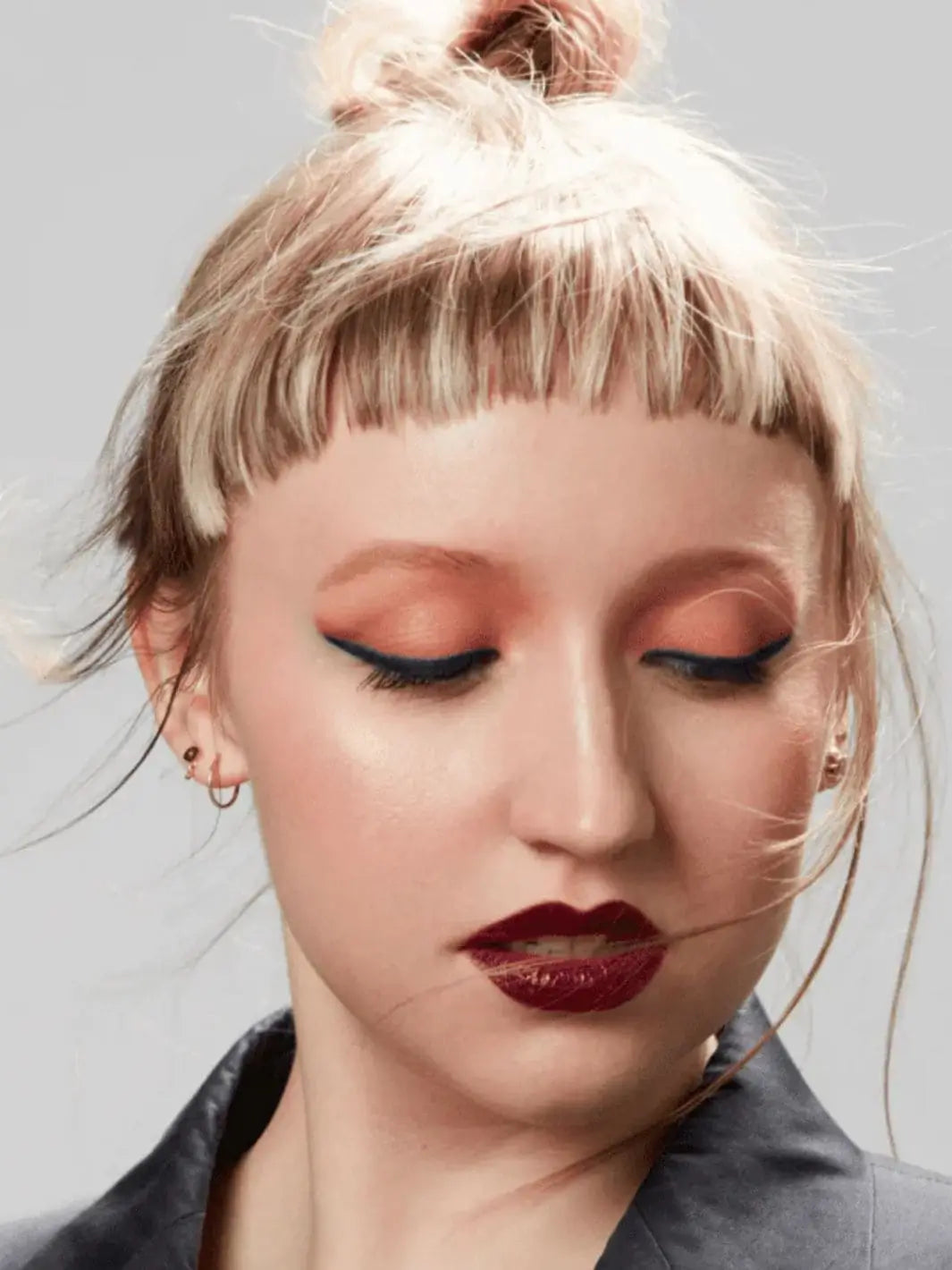 Close-up of a person with styled hair using 19/99 Beauty Precision Colour Pencil in 'Bor' against a neutral background | Twentyseven Toronto