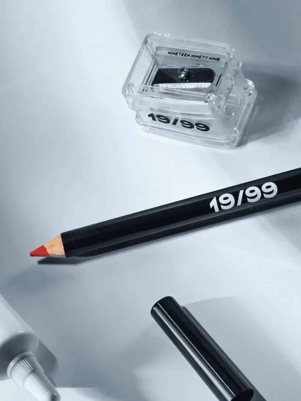 Makeup pencil and sharpener with '19/99 Beauty' branding on a light gray background | Twentyseven Toronto