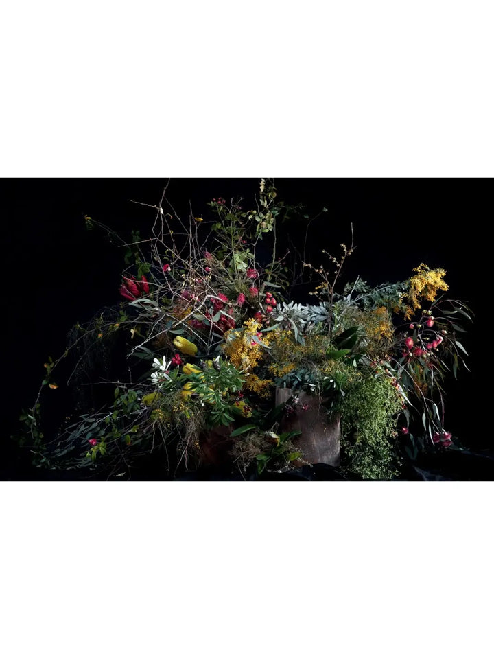 Full-spread photograph of a wild, large-scale floral installation against a dark background from Pretty Dirty: The Life of Flowers, From Creation to Compost by Melanie Stapleton | Twentyseven Toronto