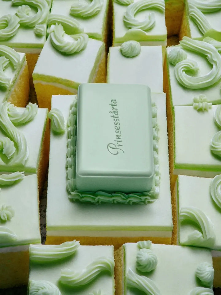 The rectangular green Flamingo Estate Prinsesstarta Milk Bar soap resting atop frosted cake slices with piped green frosting swirls | Twentyseven