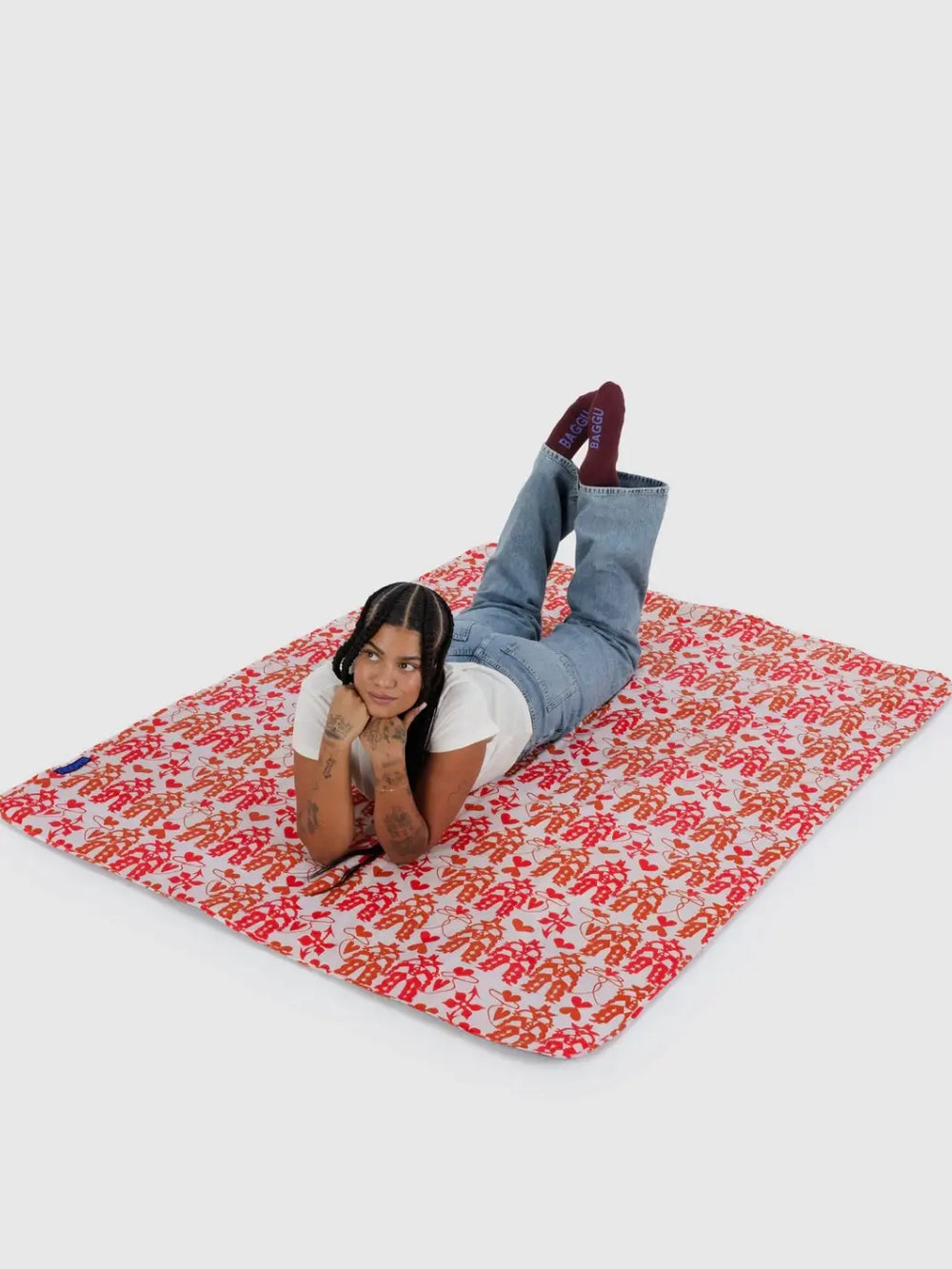 A person laying on the Baggu Puffy Picnic Blanket in Cowgirl print | Twentyseven Toronto 