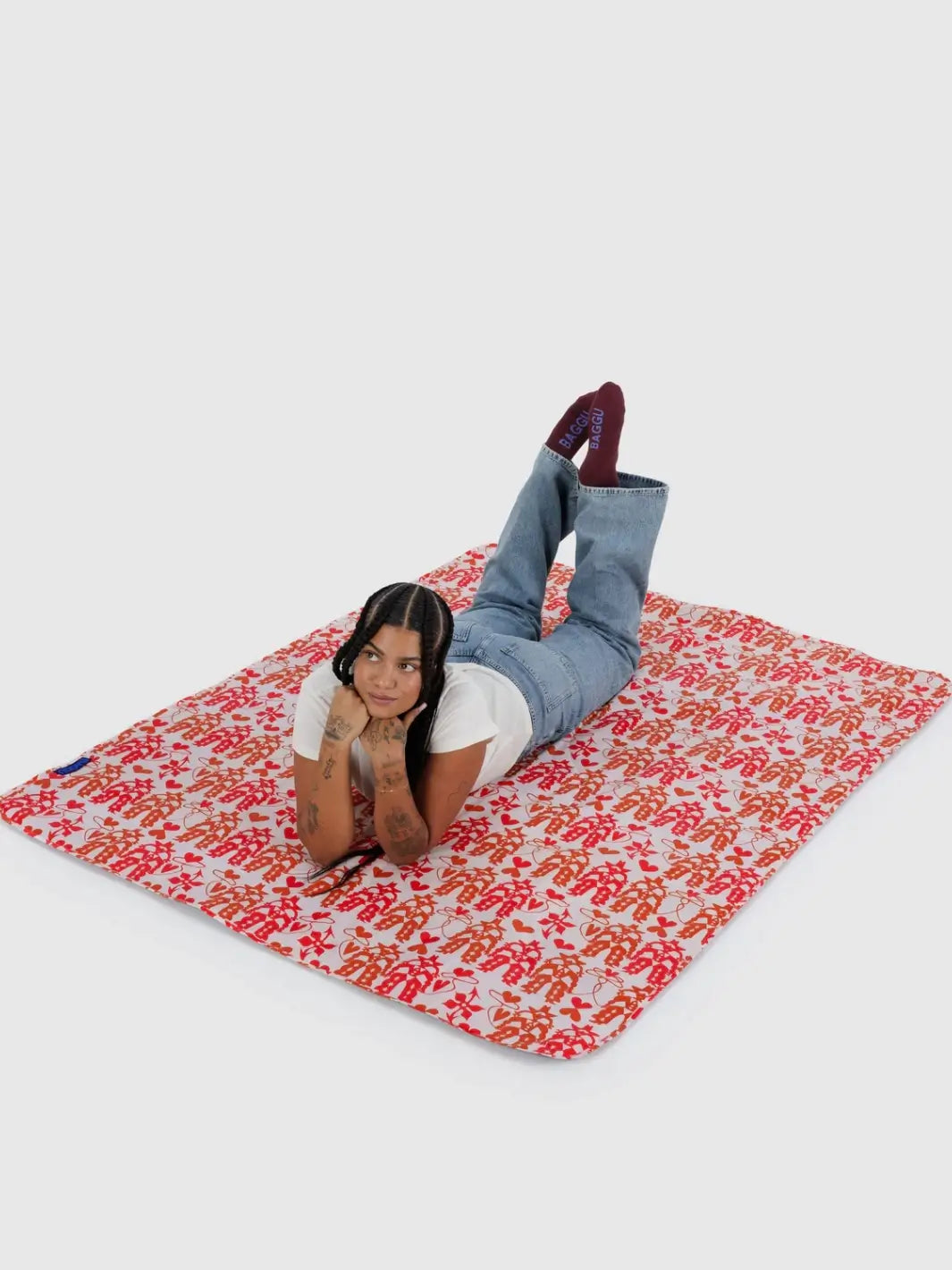 A person laying on the Baggu Puffy Picnic Blanket in Cowgirl print | Twentyseven Toronto 