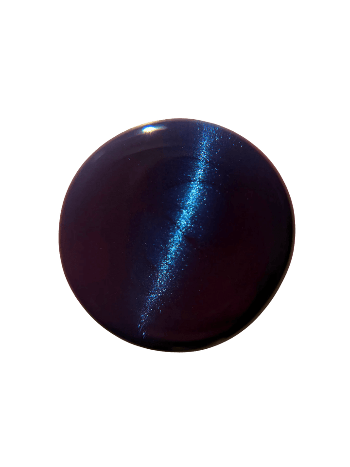 Circular color swatch on a white background displays a sharp, bright blue magnetic line running through the deep purple base of Death Valley Nails Quietude (Or Swallowing Certain Unhappiness) Magnetic Nail Polish | Twentyseven Toronto