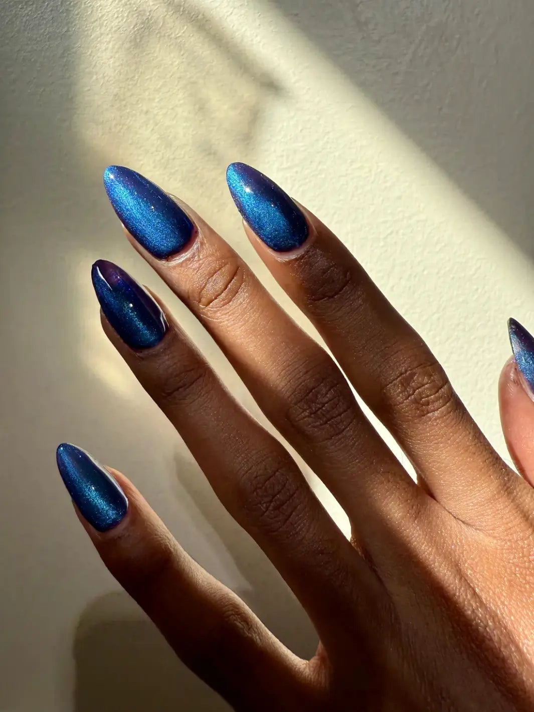 A close-up shot shows long nails painted with Death Valley Nails Quietude (Or Swallowing Certain Unhappiness) Magnetic Nail Polish, highlighting the luminous cat-eye effect in the center of each nail | Twentyseven Toronto