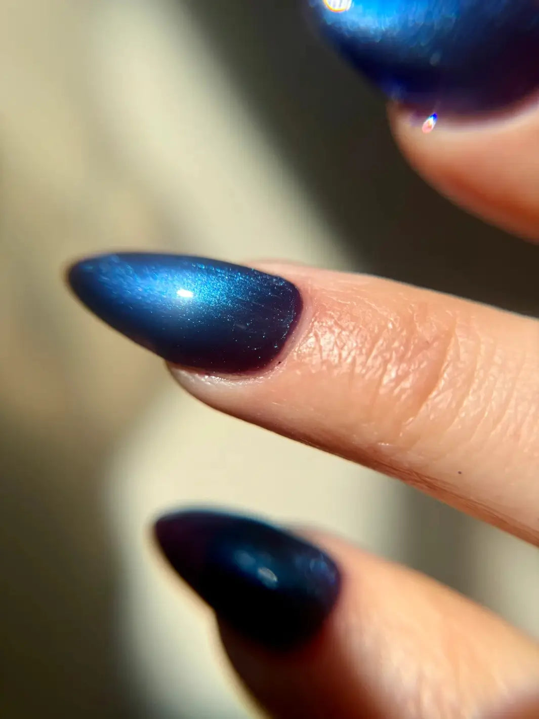 An extreme close-up captures a single fingernail to show the detailed sparkle and deep blue color gradient of Death Valley Nails Quietude (Or Swallowing Certain Unhappiness) Magnetic Nail Polish | Twentyseven Toronto