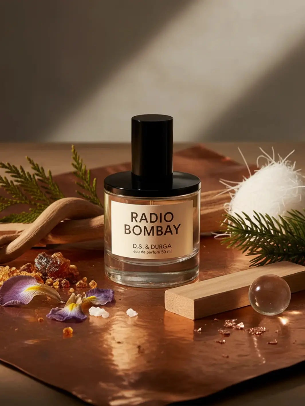 Perfume bottle labeled 'Radio Bombay' from DS & Durga on a wooden surface with decorative elements | Twentyseven Toronto