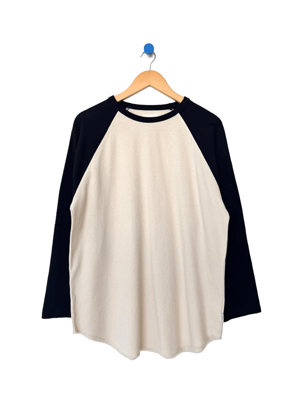 Heavy Cotton Raglan Tee in Naturel/Black on a wooden hanger, featuring a cream body, contrasting black long raglan sleeves, ribbed crew neckline and curved hem | Twentyseven Toronto