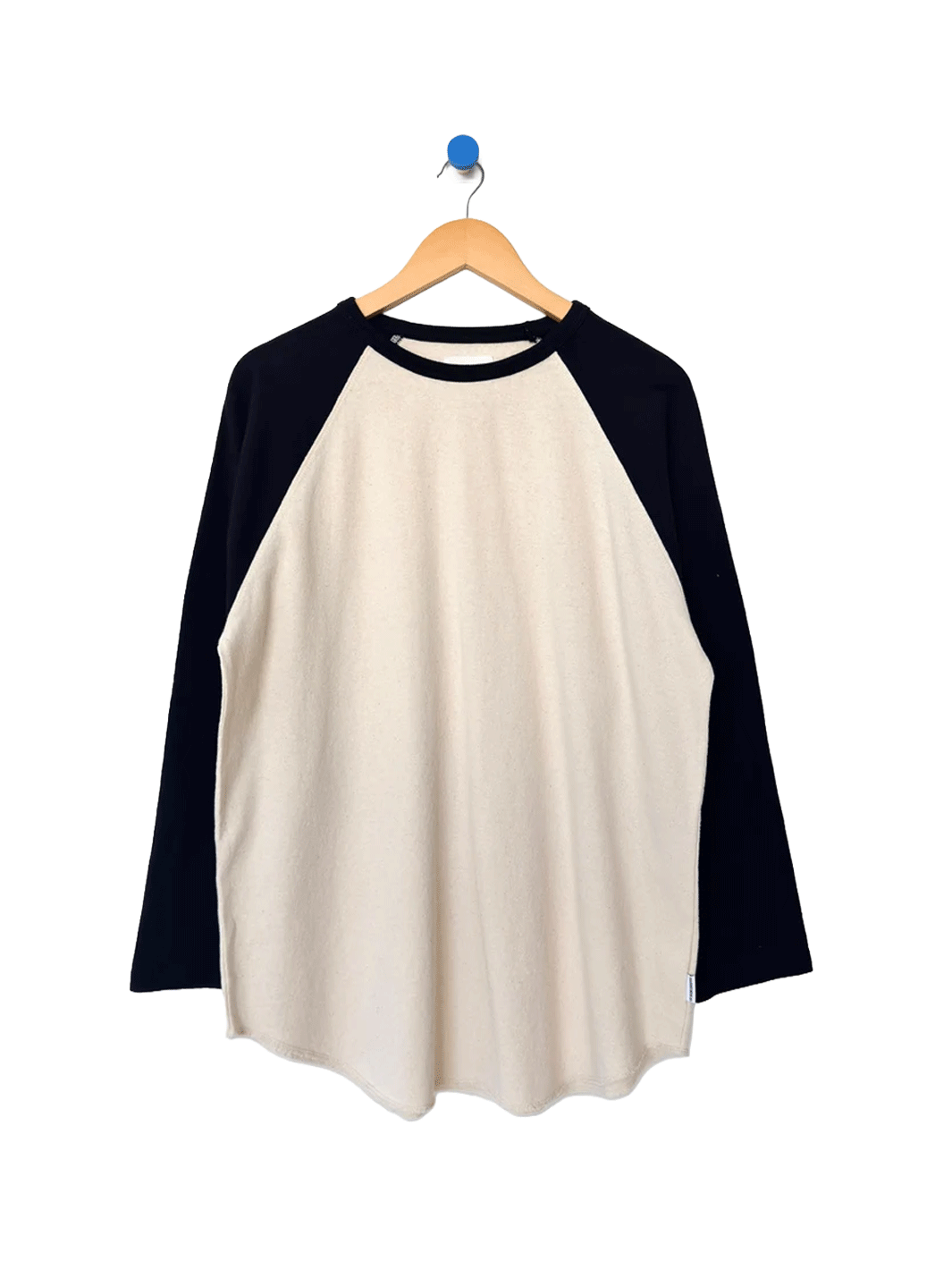 Heavy Cotton Raglan Tee in Naturel/Black on a wooden hanger, featuring a cream body, contrasting black long raglan sleeves, ribbed crew neckline and curved hem | Twentyseven Toronto