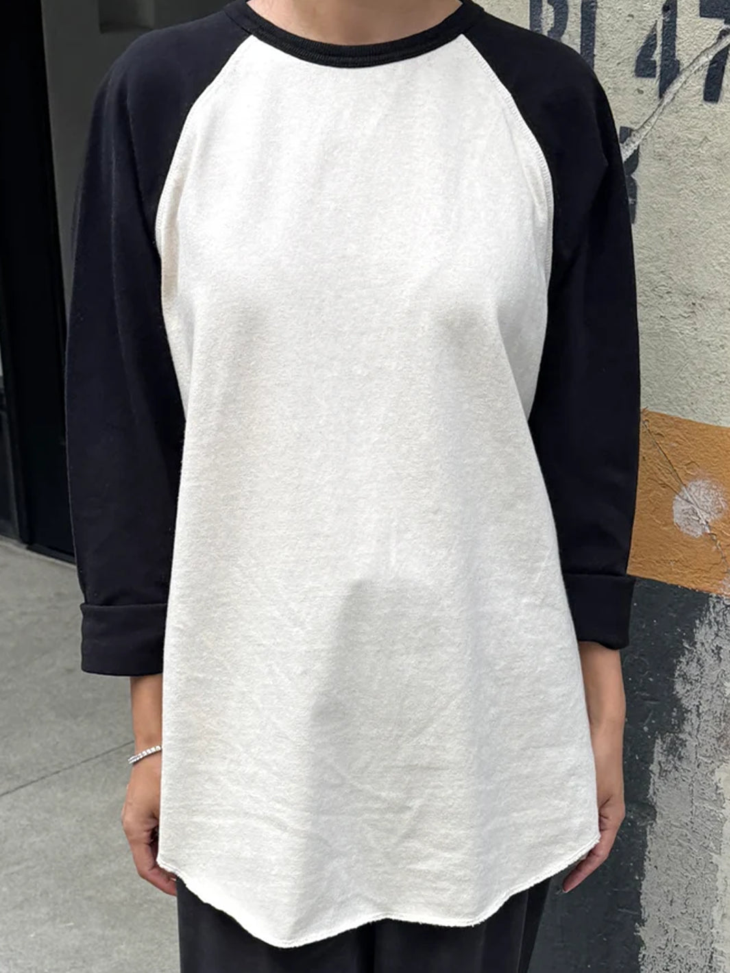 Front view of model wearing Heavy Cotton Raglan Tee in Naturel/Black, featuring contrasting black long sleeves, a cream body, ribbed crew neckline and rounded hem | Twentyseven Toronto