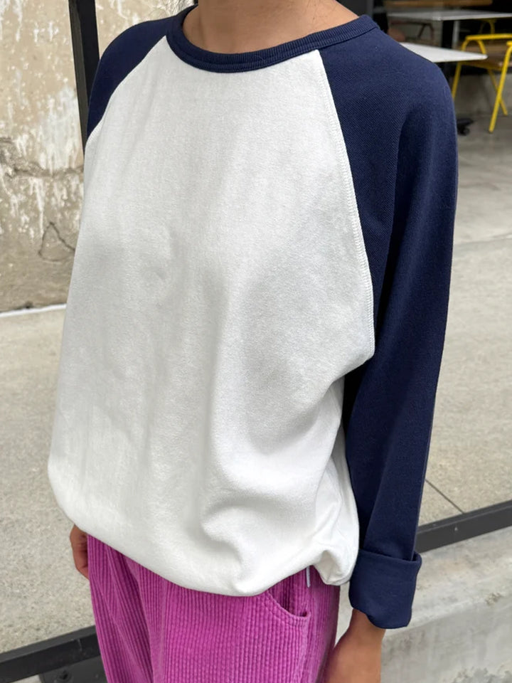 Image 1: Model wearing the Le Bon Shoppe Raglan Tee in white with midnight navy sleeves | Twentyseven Toronto